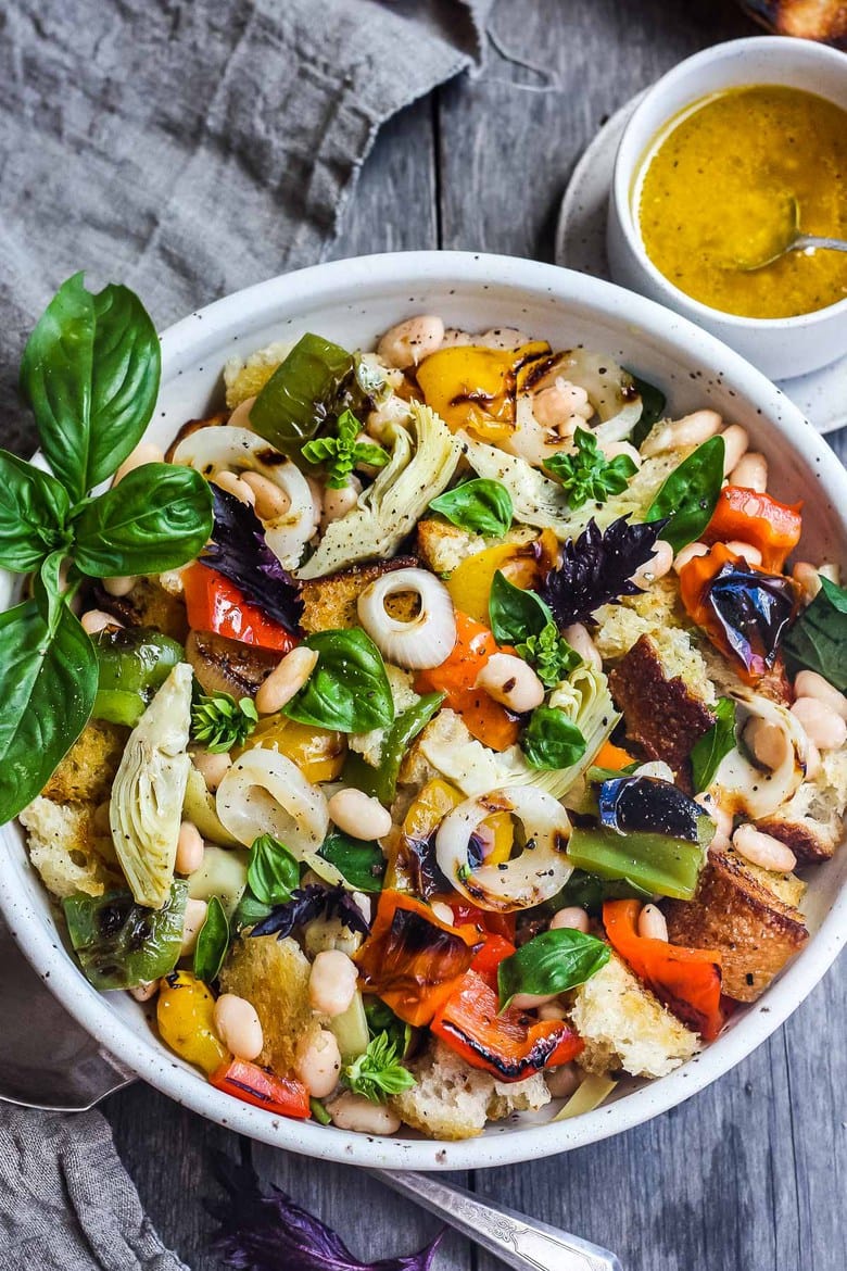 grilled Tuscan bread salad with grilled veggies, white beans, and basil in serving bowl. 